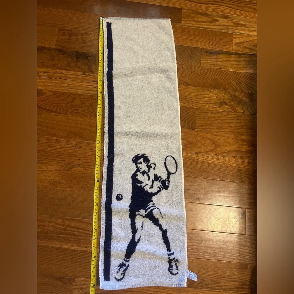 2 sports towels. 1 is reversible and has a tennis player. 1 is izod brand.